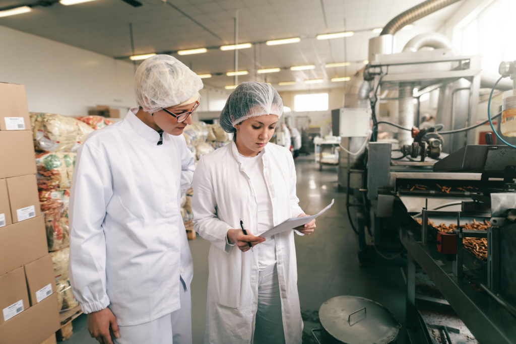 Workers evaluating safety checklists in a factory